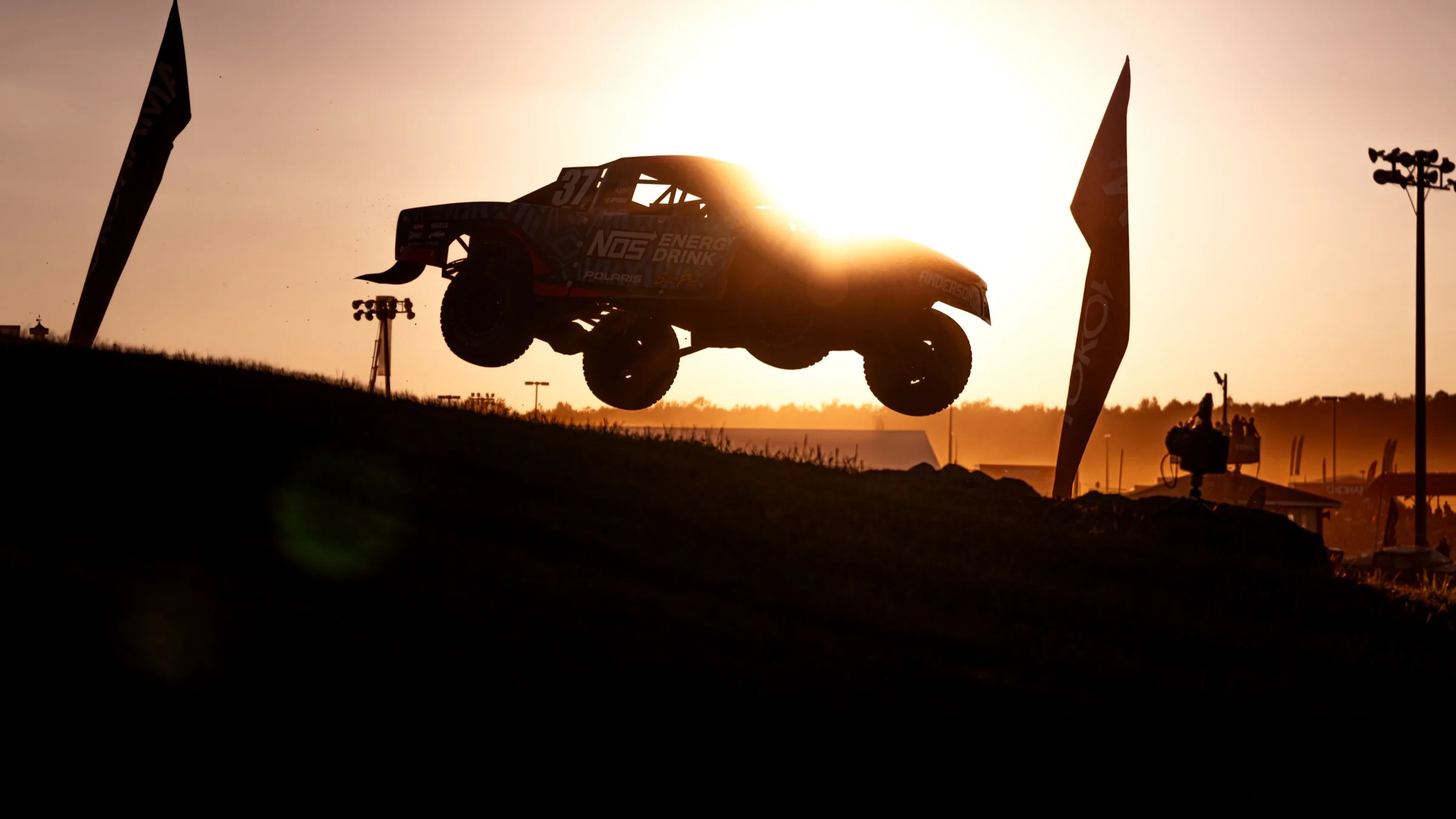 Airborne off-road vehicle at sunset