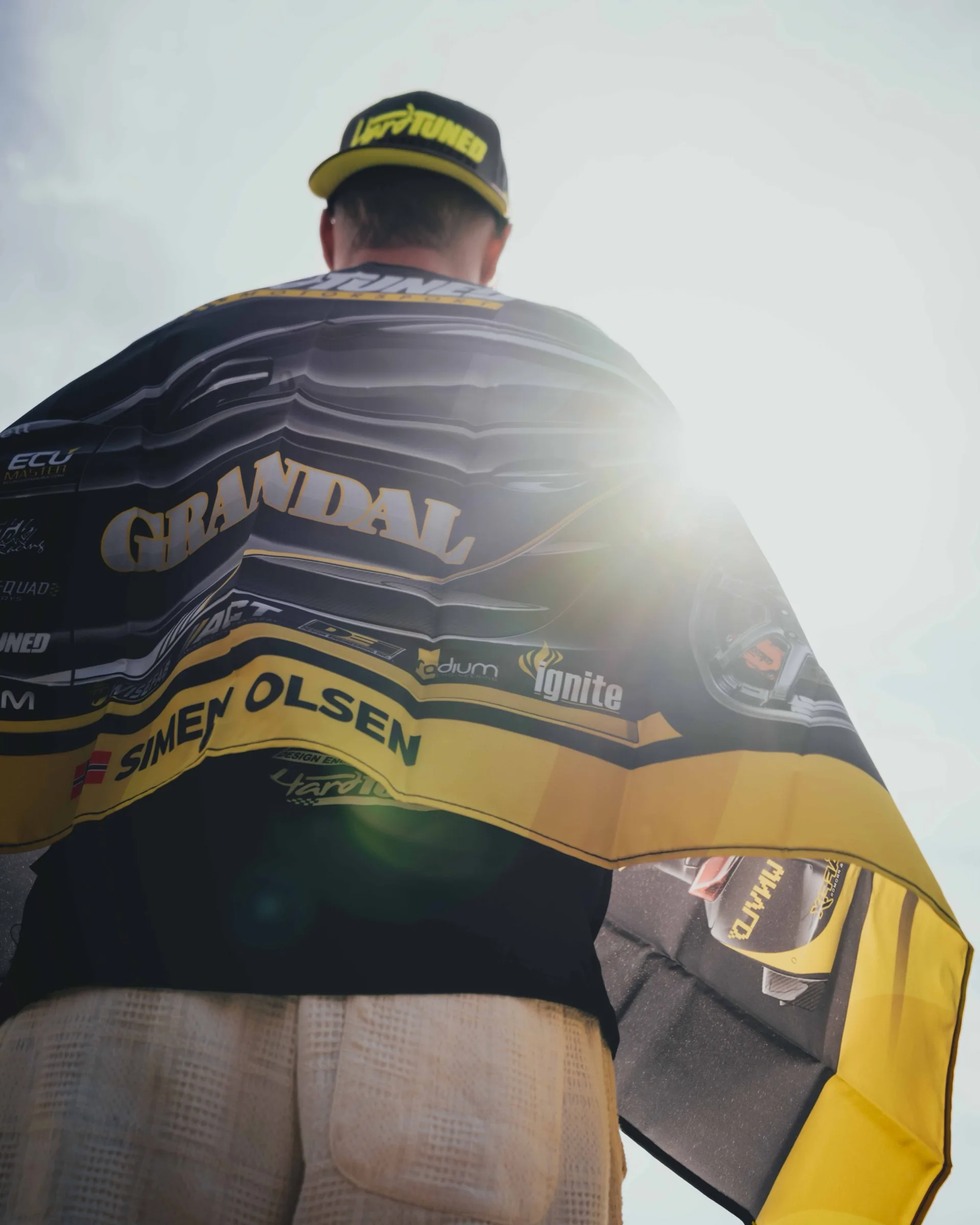 Motorsport driver wrapped in team flag