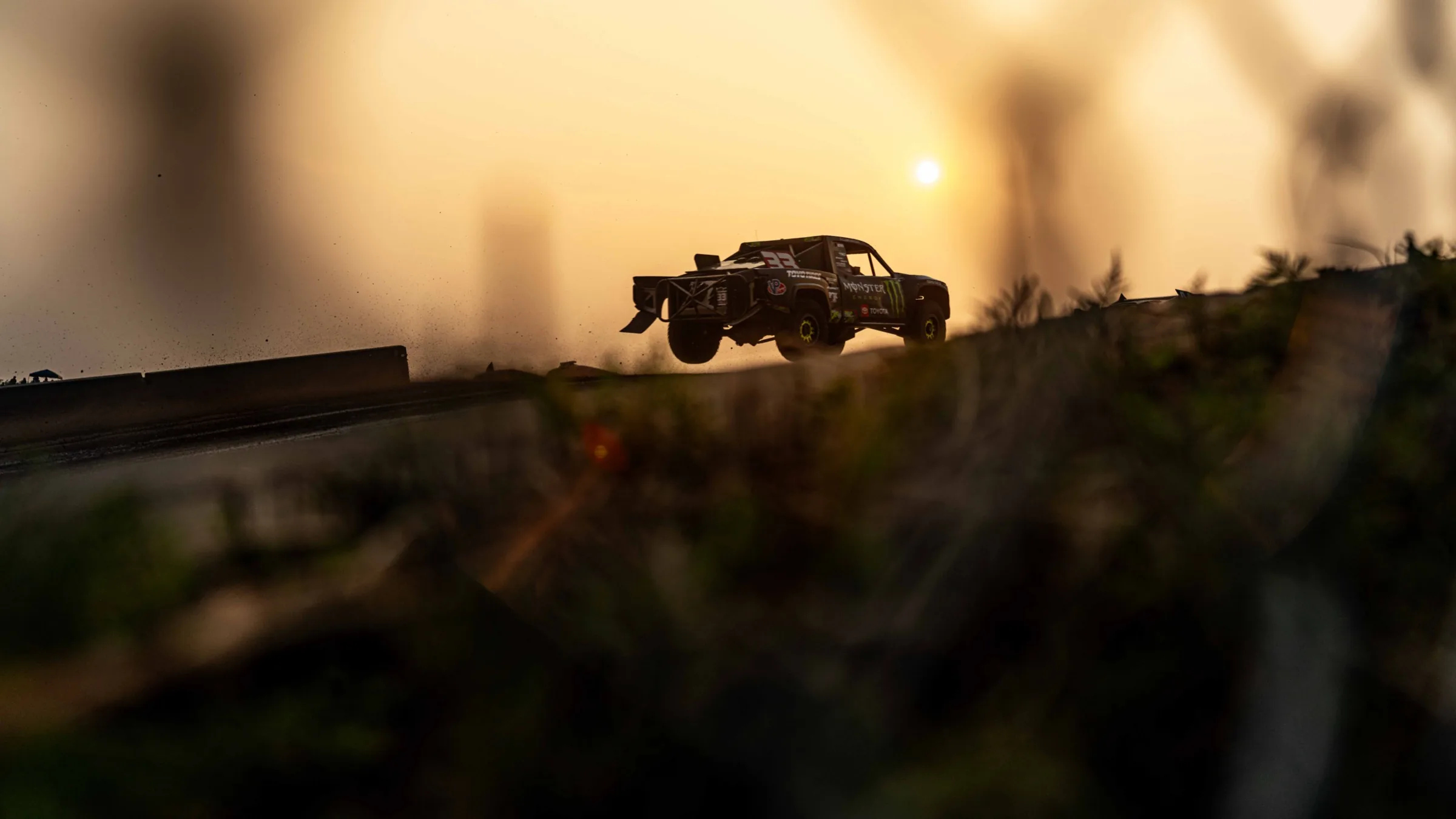 Off-road truck airborne at sunset